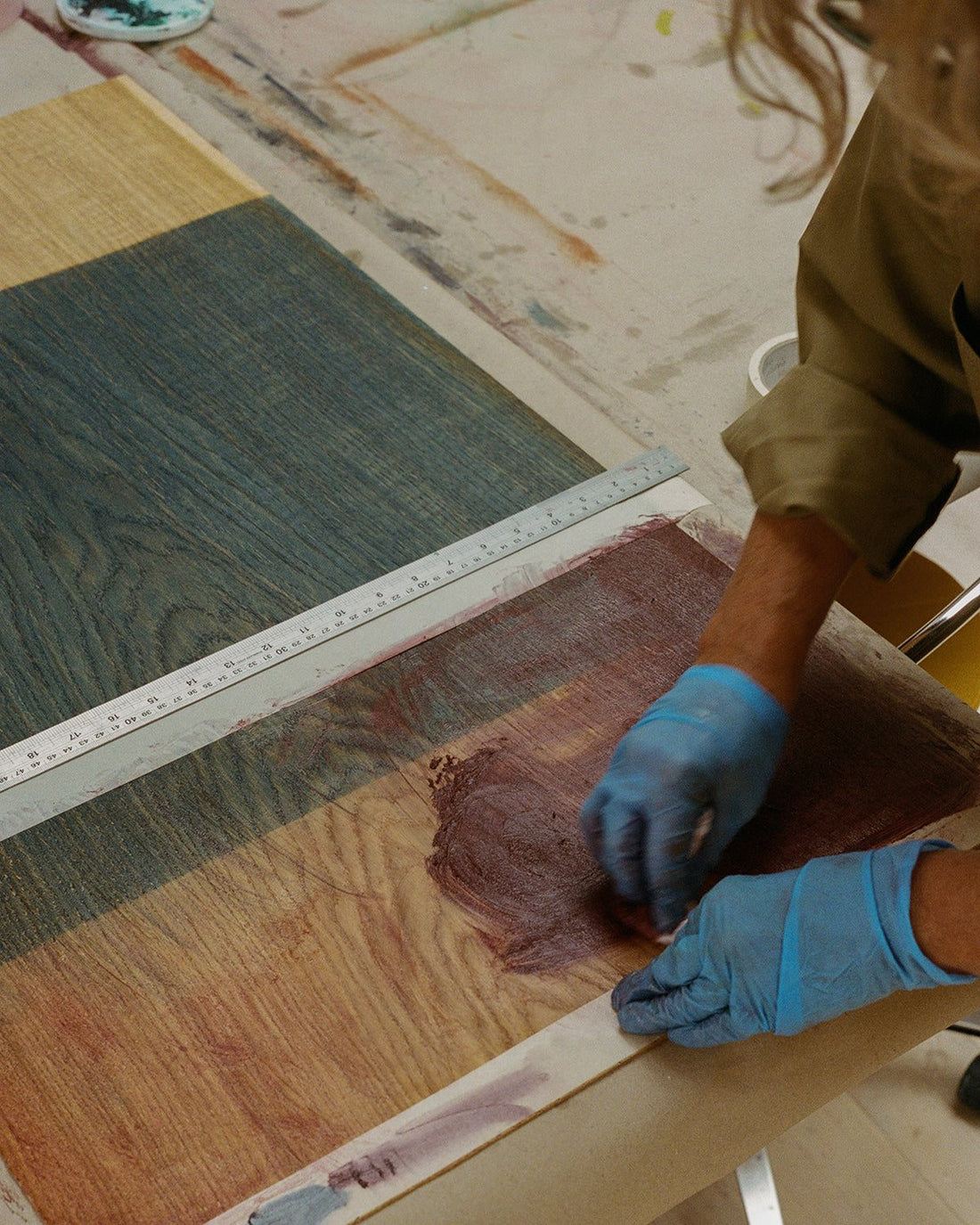 Gloved hands rub pigment into the leather of an Adam Stool: artist Malene Bach colours it for the FRAMA Artisan Edition.