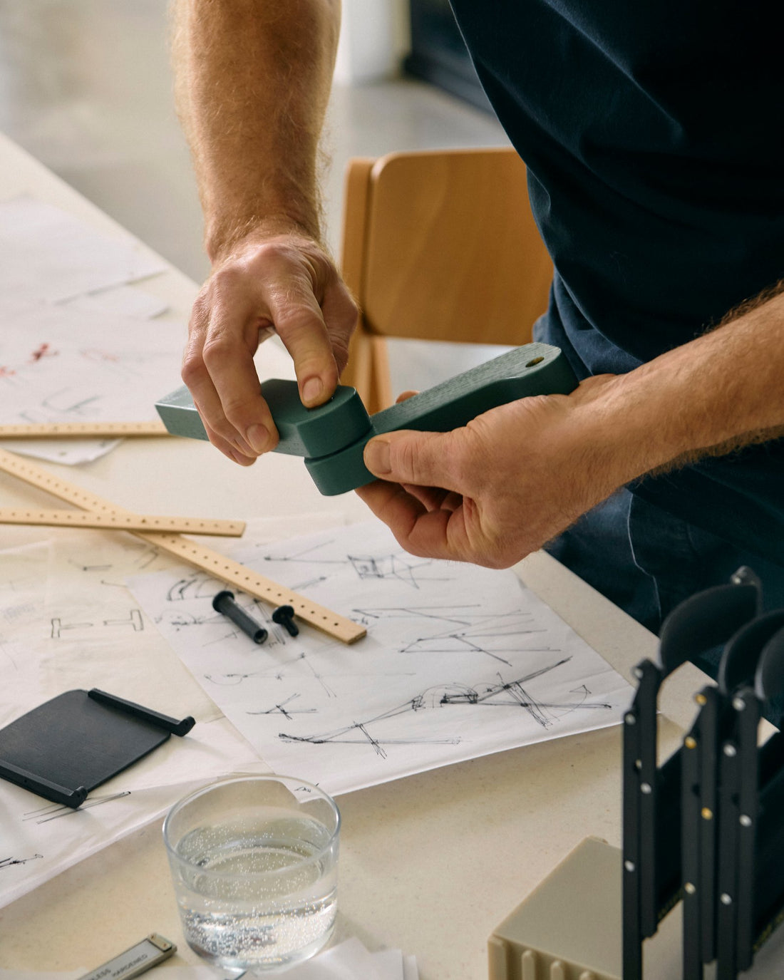 Hands fit together a model part of the Backflip chair over sketches in Gudmundur Ludvik's studio