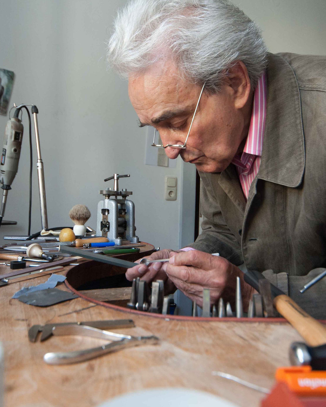Designer Peter Raacke files a small metal piece at his workbench.