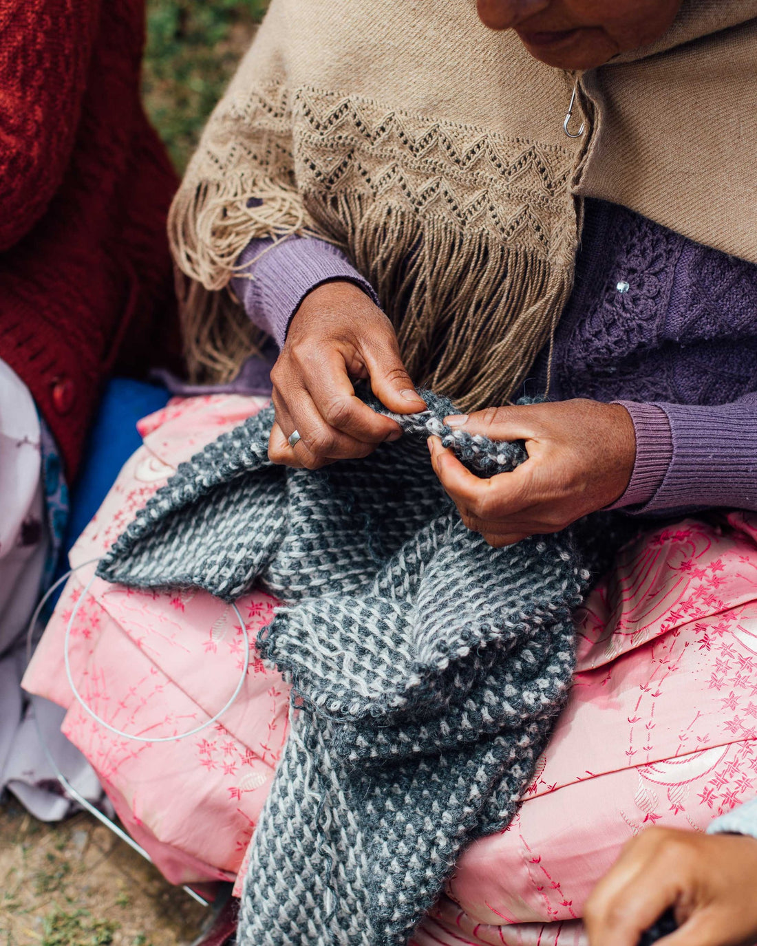 A craftswoman in Bolivia hand-knitting baby llama wool.